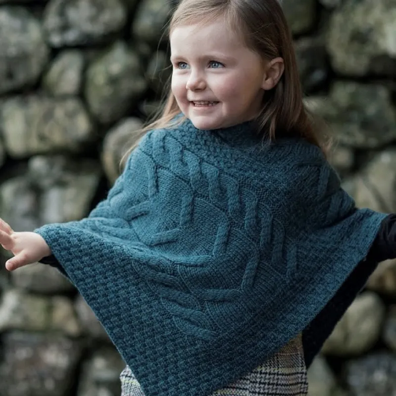 Child wearing a green knitted cape